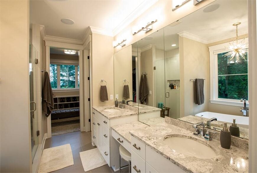 The primary bathroom offers a shower and a large dual sink vanity. There's a door on the side that opens to the walk-in closet.
