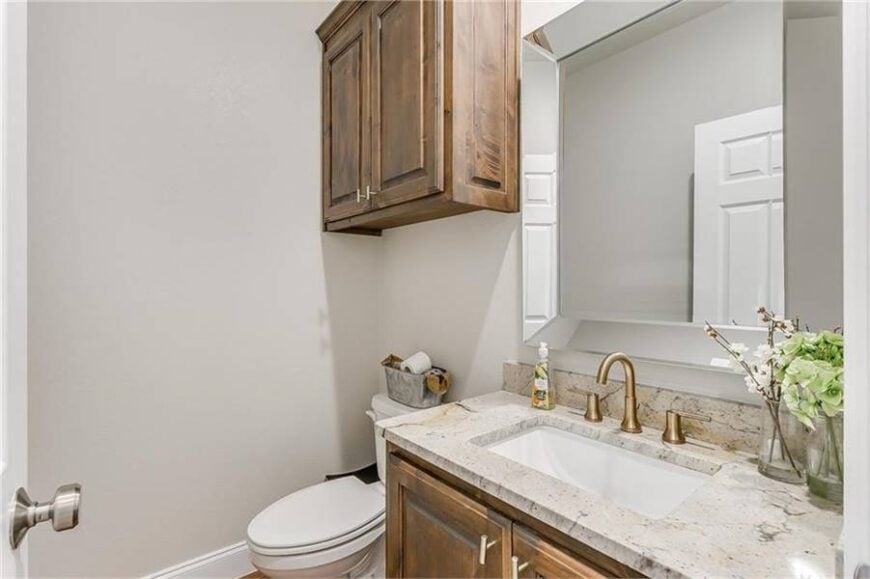This bathroom offers a sink vanity and a toilet situated under the floating cabinet.