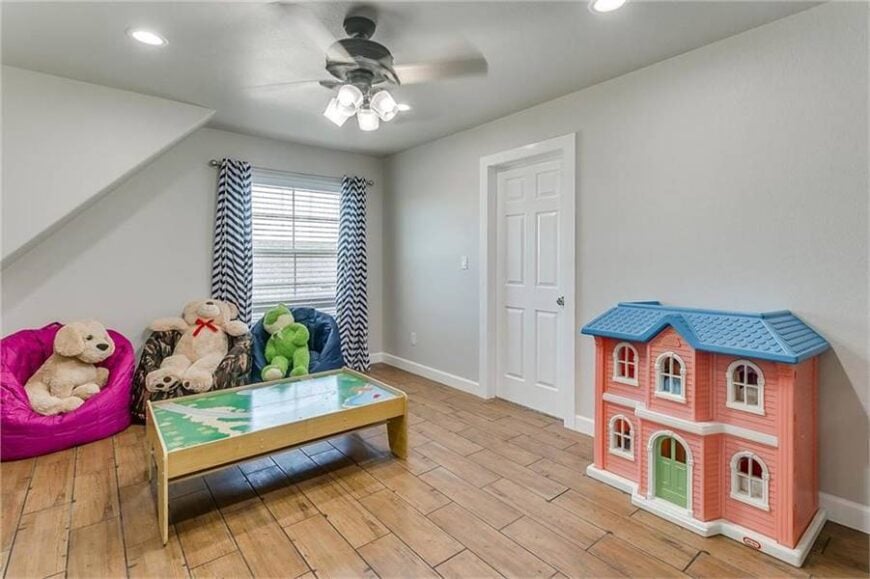 This bedroom has colorful bean bag chairs and a pink dollhouse perfect for kids.