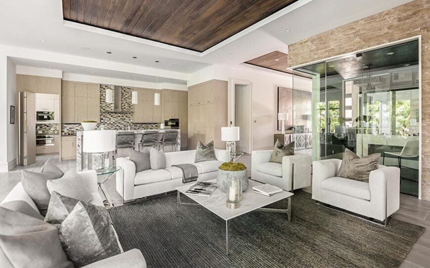 The opposite view shows the open kitchen behind illuminated with cylindrical pendants and recessed ceiling lights.