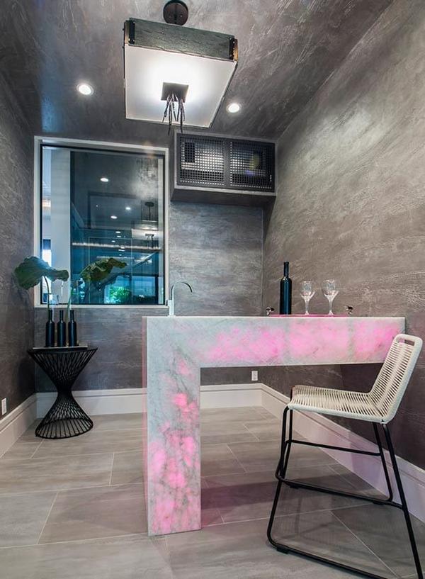 A wet bar boasting a glowing counter that's fitted with an undermount sink.