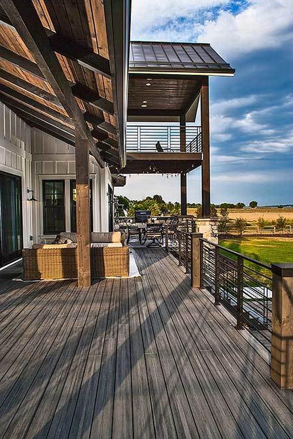 A closer view of the covered deck showing the natural hardwood flooring and wicker seats.