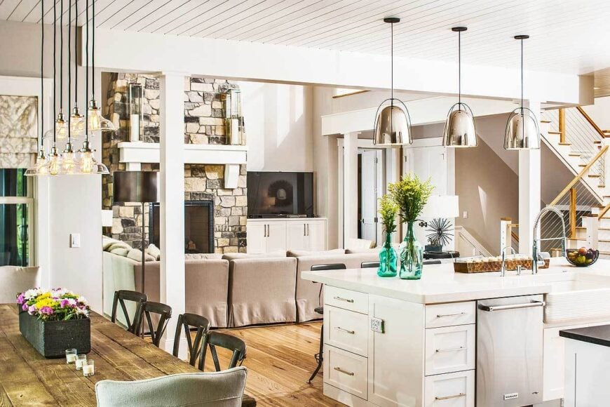 An open layout view showing the soaring living room and shared dining and kitchen defined with interior columns.
