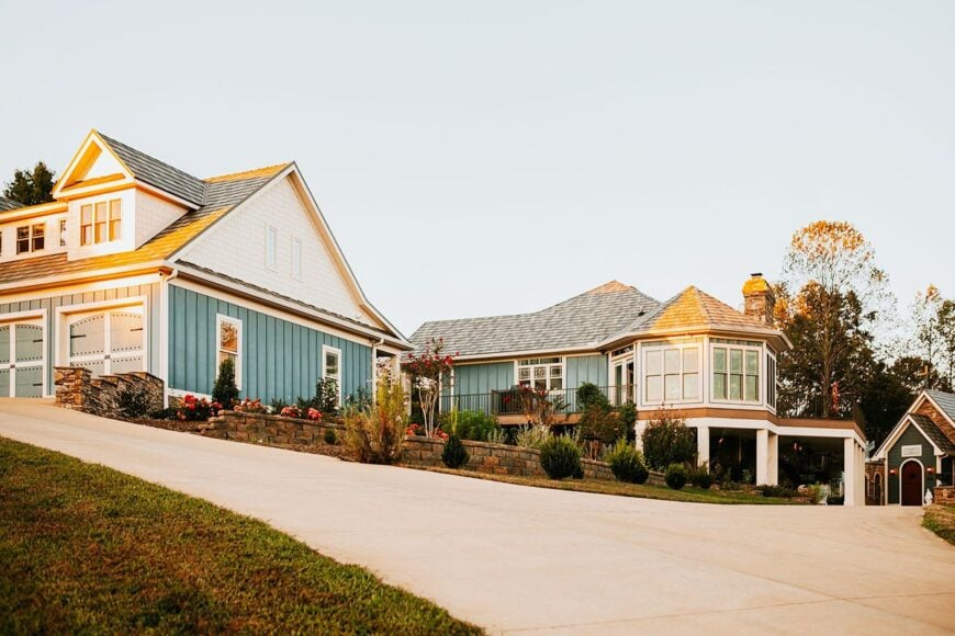 Side exterior view showing the garage, upper balcony, and a charming turret that sits on top of the covered patio.