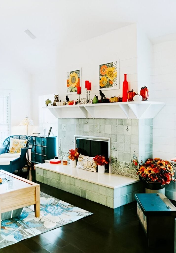 The angled view shows the cozy wicker seat and a wooden coffee table that sits on a floral area rug.