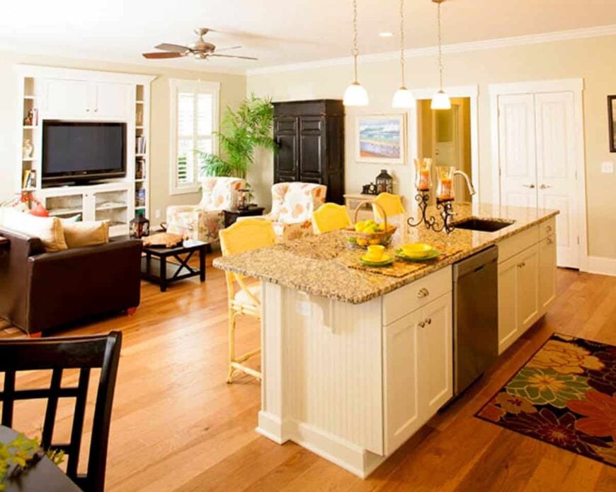 The living room offers a TV and a dark wood coffee table flanked with a brown sofa and floral wingback chairs.