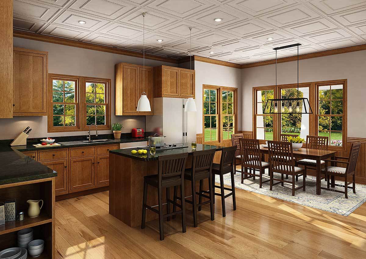An eat-in kitchen showcasing a rectangular dining set over the bordered area rug along with wooden cabinets that match the center island.