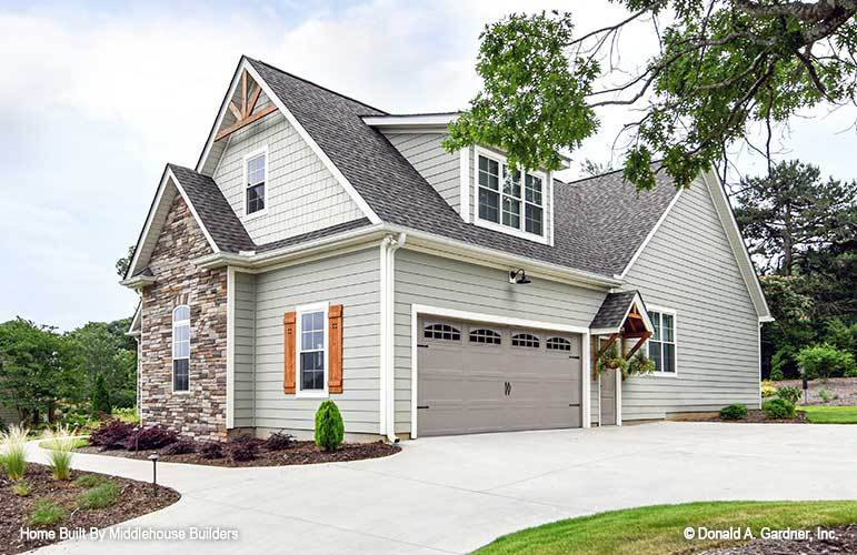 Home facade clad in gray exterior siding and striking stone accents. Decorative wood trims adorn the gable roof.