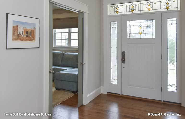 The foyer has a white front door graced with stained glass panels.