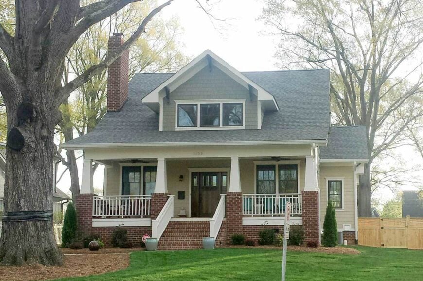 Home's front view showing the large front porch and a center dormer window that sits on the gable roof.