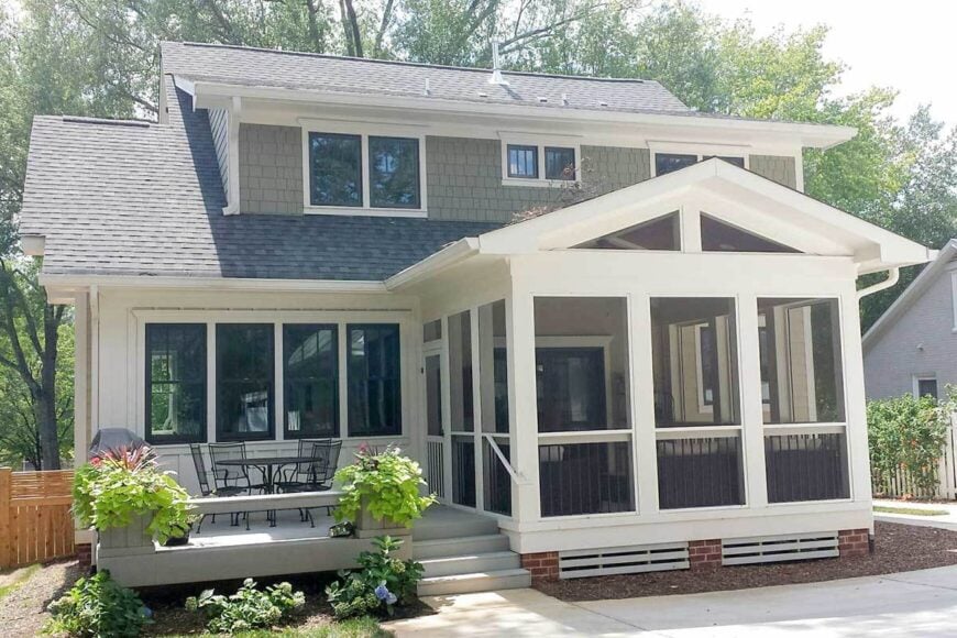 There's an open deck on the side filled with a round table and matching metal chairs.