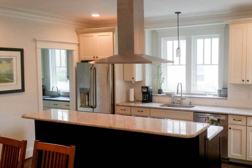 Natural light flows in through the white-framed windows of the kitchen.