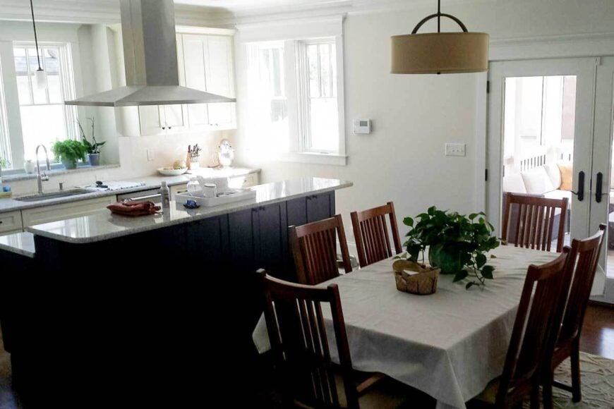 The dining area offers wooden chairs and a rectangular dining table dressed in a white mantel.