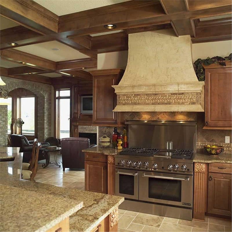 The kitchen offers a two-tier bar, wooden cabinets, and a double oven range placed under the bespoke vent hood.
