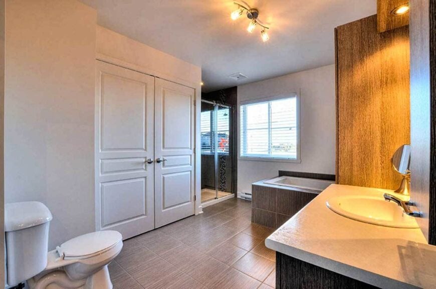 Bathroom with a sink vanity, toilet, walk-in shower, and a drop-in bathtub.