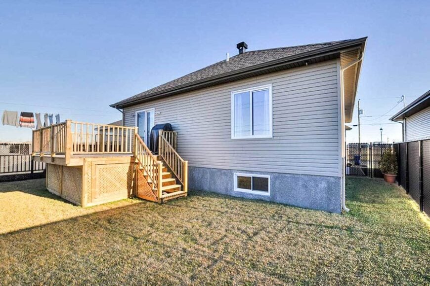 Home's rear view showing the horizontal exterior siding and a sundeck framed with wooden railings.