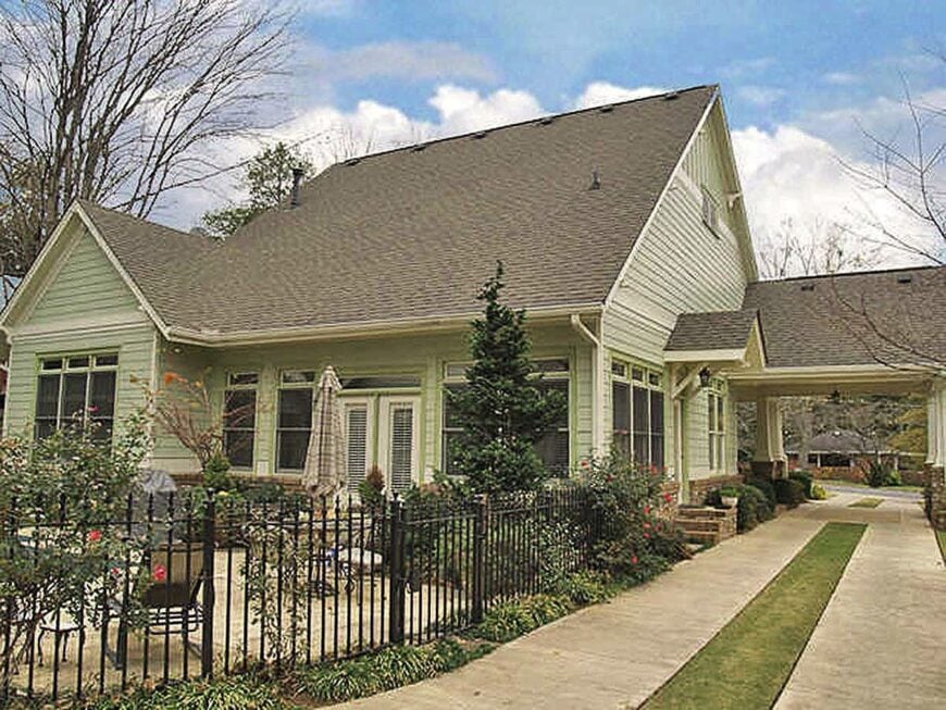 Side exterior view with an open patio and a carport topped with a gable roof.