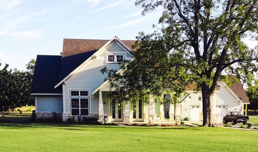 Rear exterior view showing the two-car garage and covered porch supported by tapered columns.