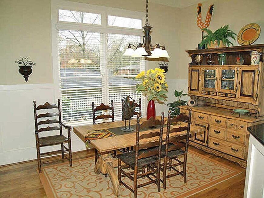 Formal dining room with wooden buffet cabinet, a rectangular dining table, and dark wood chairs sitting on a patterned area rug.