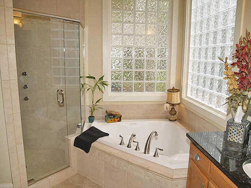 Primary bathroom with a walk-in shower and a corner tub fixed under the glass cube windows.