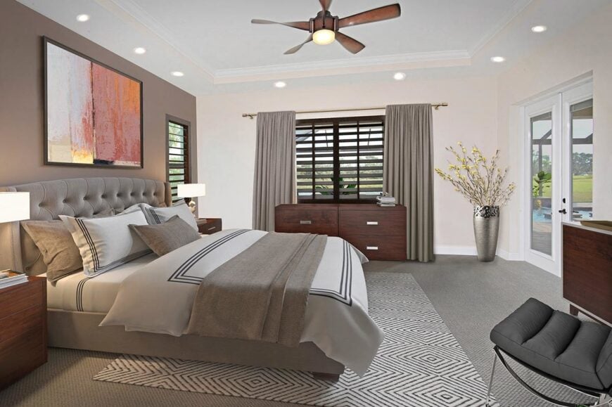 The primary bedroom has a tray ceiling, louvered windows, and a french door that leads out to the airy lanai.