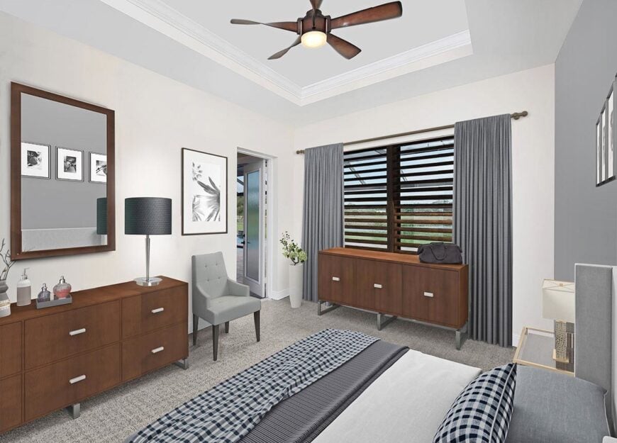 This bedroom offers wooden console tables and a gray upholstered bed that matches the tufted armchair under the framed artwork.