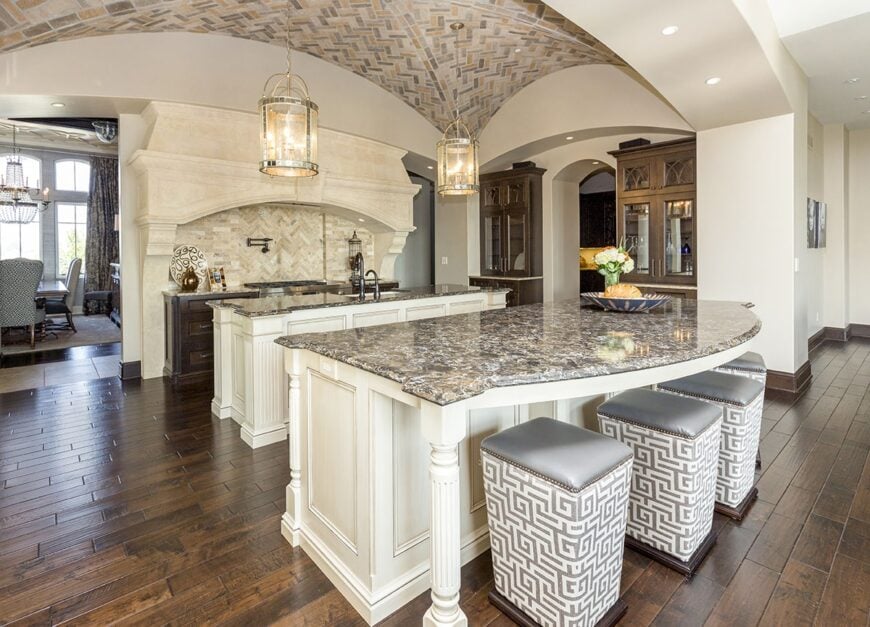 The kitchen has natural hardwood flooring and a magnificent groin vault ceiling mounted with glass pendant lights.