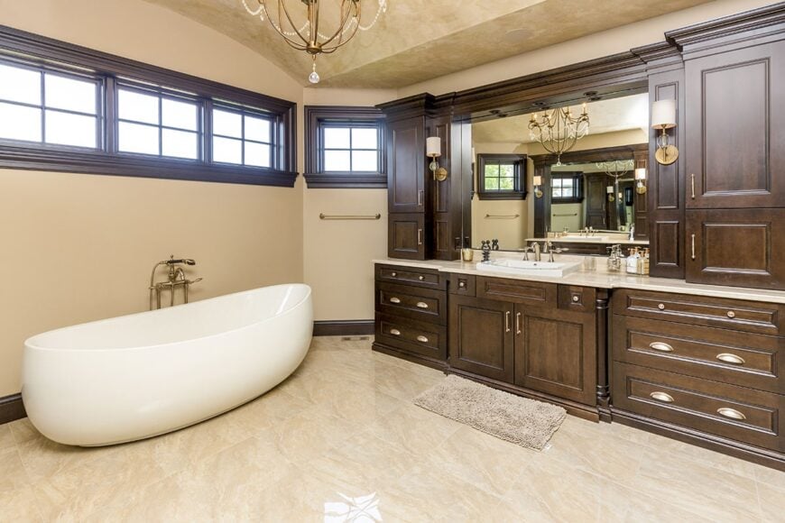 The primary bathroom offers a freestanding tub and a large sink vanity paired with a beige shaggy rug.