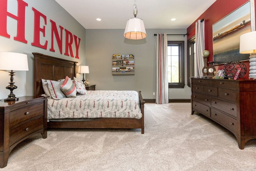 This bedroom offers dark wood furnishings, a beige carpet flooring, and wooden framed windows covered in striped curtains.