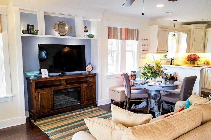 Living room with a comfy beige sofa and a flatscreen TV sitting on a wooden stand.