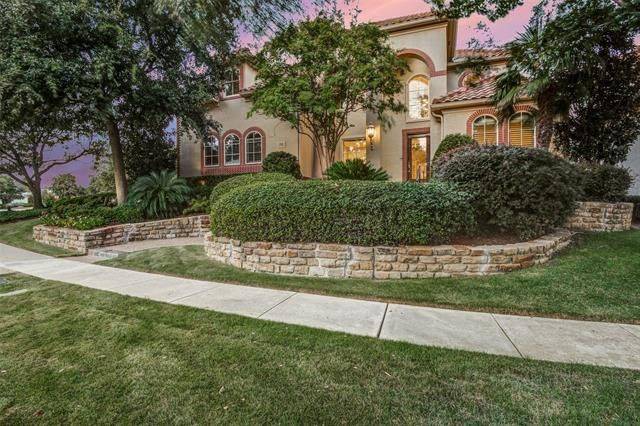 A concrete walkway wraps around the manicured bushes and the home's facade.