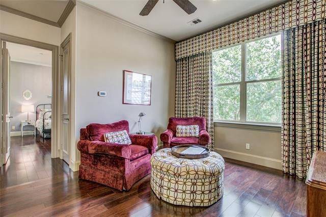 Game room with red velvet armchairs and a tufted ottoman that matches the patterned drapes and valence adorning the framed window.