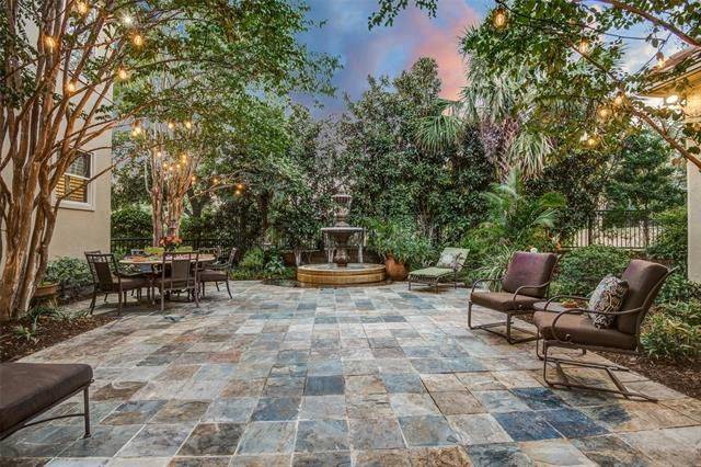 This amazing outdoor space offers multiple seats, a round dining set, and a fountain serving as a dazzling focal point.
