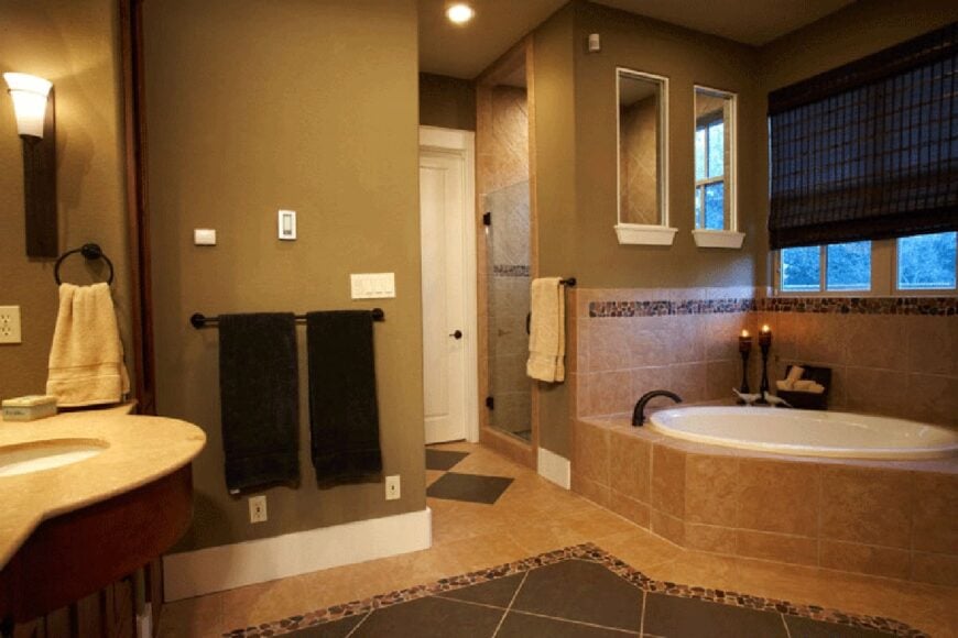 Primary bathroom equipped with a walk-in shower, a sink pedestal, and a deep soaking tub clad in beige marble tiles.
