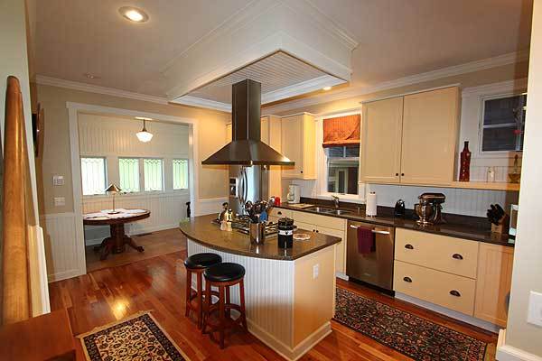 Sitting across the kitchen is the breakfast nook that features a round wooden table.