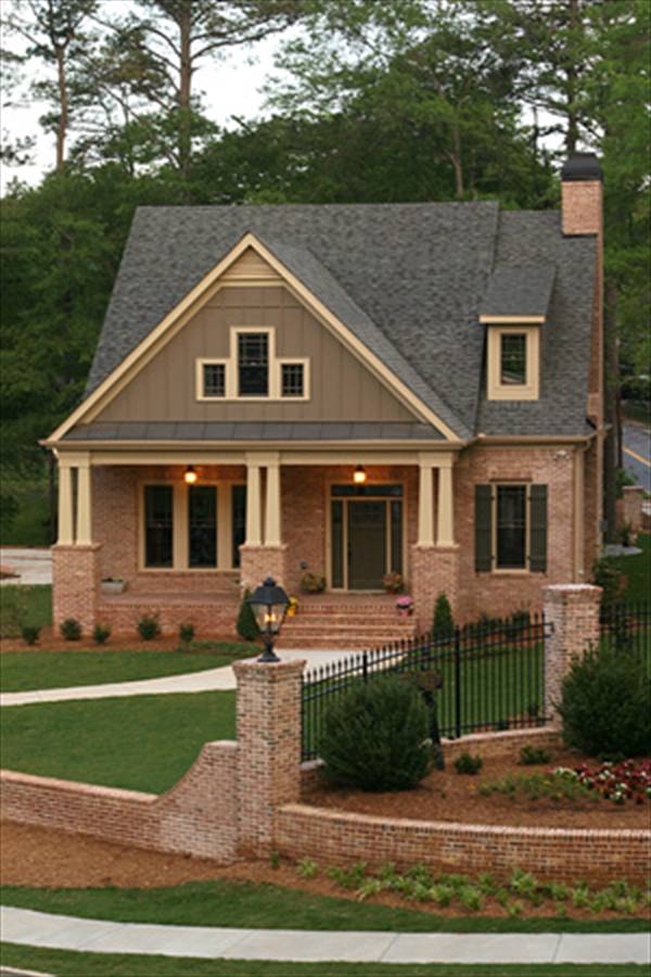 Home facade with red brick exterior and a covered porch framed with decorative columns.