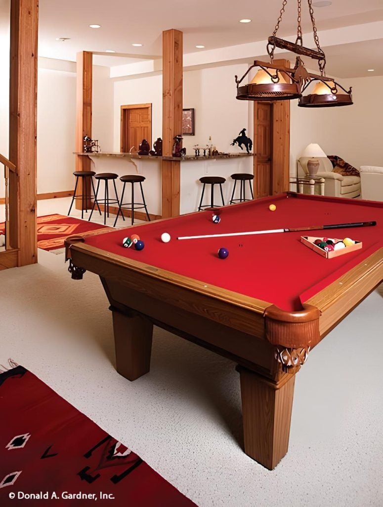 Recreation room with a wrapped around wet bar and a billiard table under the vintage pendant light.