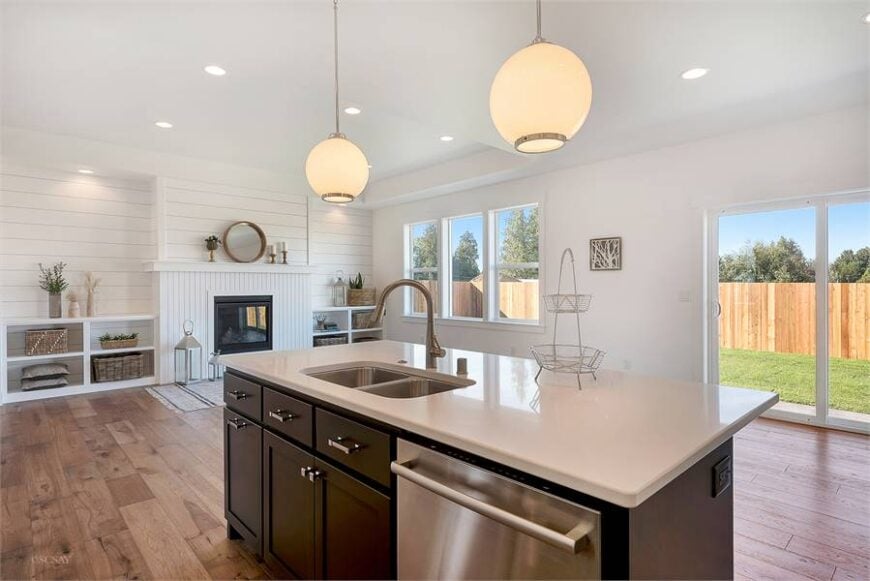 The kitchen island is fitted with a double bowl sink and a stainless steel dishwasher.