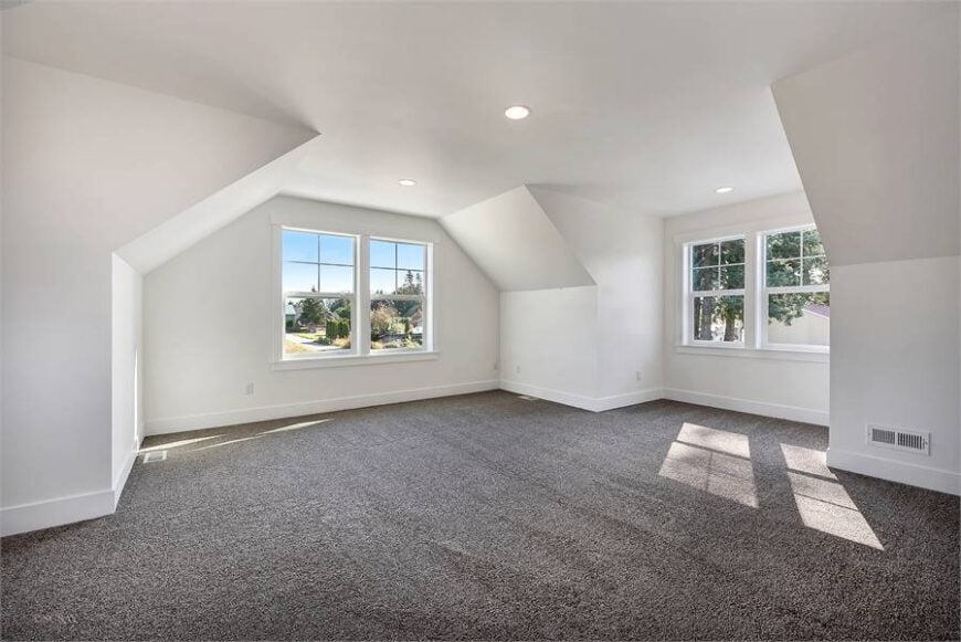 Bonus room with vaulted walls, white-framed windows, gray carpet flooring, and a regular ceiling.