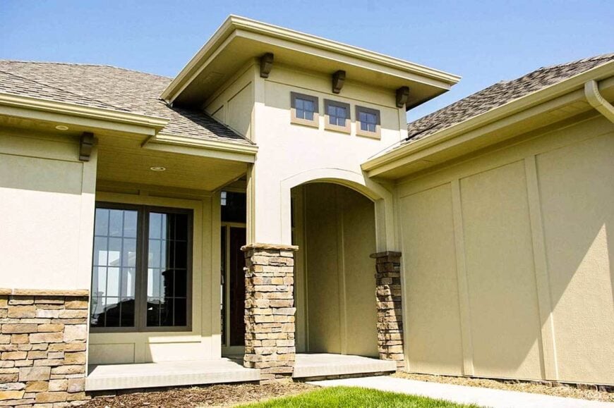 A closer look at the front porch shows the slightly raised concrete flooring and an open archway inlaid with stone brick accents.