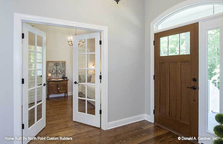 The foyer features a wooden entry door fitted with glass panels. A white french door on the side opens to the flexible study/bedroom.