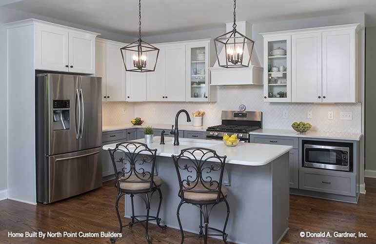 The kitchen is equipped with stainless steel appliances, quartz countertops, and an undermount sink fitted on the center island.