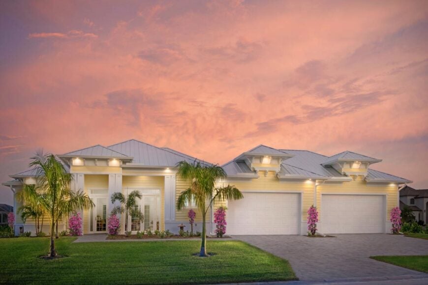 Home front view with covered front porch and a three-car garage topped with dormer windows.