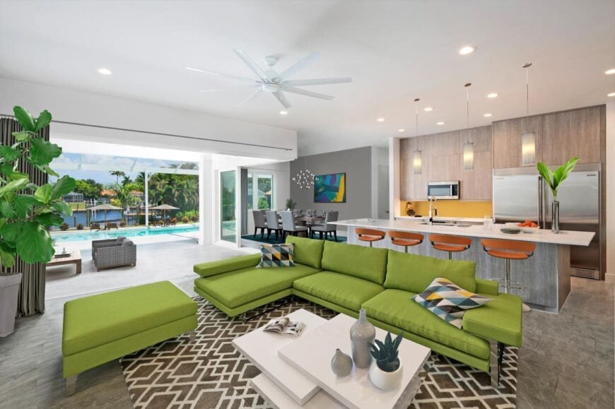 An open layout view showing the living room, kitchen, dining area, and the covered lanai with a swimming pool.