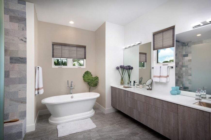 The primary bathroom offers a freestanding tub and a dual sink vanity paired with frameless mirrors.