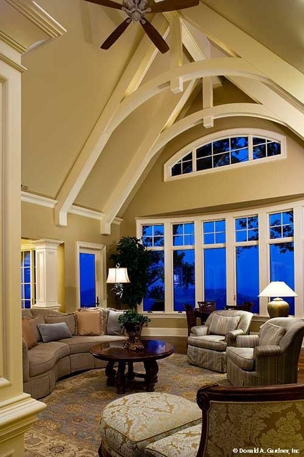 A curved sectional sofa, striped armchairs, classy lounge chair, and a round coffee table complete the living room.