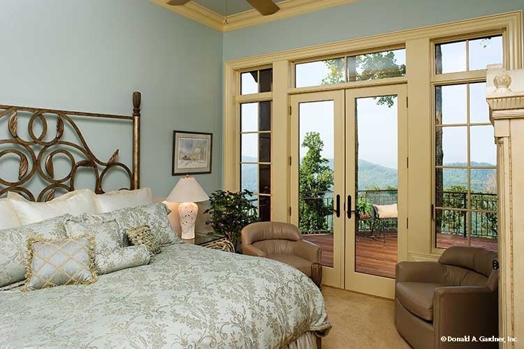 The primary bedroom offers an ornate brass bed, leather round chairs, and a private deck accessible via the french door.