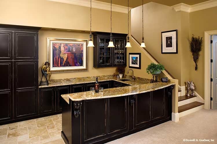 Wet bar with dark wood cabinets, granite countertops, and a two-tier peninsula illuminated by small glass pendants.