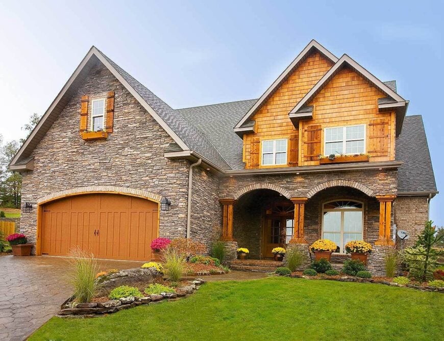 Front exterior view with a double garage and a covered front porch framed with decorative arches.