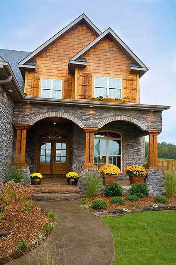 A curved flagstone walkway leads to the home entry with a wooden front door.
